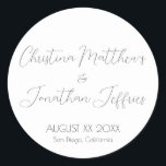 Modern and Elegant White Wedding Classic Round Sticker<br><div class="desc">This modern and elegant event or wedding sticker features a simple white background with black text. The names of the couple are printed in a script font. The wedding date and location are printed below.</div>