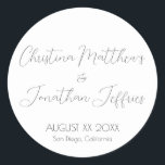 Modern and Elegant White Wedding Classic Round Sticker<br><div class="desc">This modern and elegant event or wedding sticker features a simple white background with black text. The names of the couple are printed in a script font. The wedding date and location are printed below.</div>