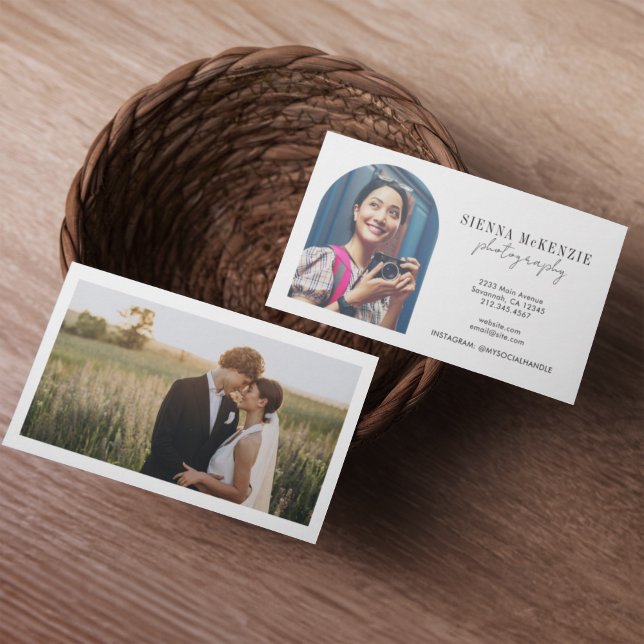 Modern Arch Script Photography Professional Business Card (Two business cards in a woven basket on a wooden table. One card shows a smiling woman with a camera)