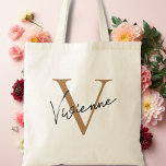 Modern Elegant Gold Black Personalised Monogram Tote Bag<br><div class="desc">Introducing the perfect accessory for any bridal party, the Modern Elegant Gold Black Personalised Monogram Tote Bag! With its chic and sophisticated design, this bag is sure to complement any wedding aesthetic, whether you're going for a modern, elegant, or simple look. Crafted from high-quality materials, this tote bag features a...</div>