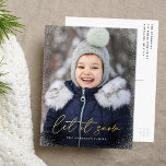 Modern Let it Snow Script Photo Foil Holiday Postcard<br><div class="desc">Wish friends and family a happy holiday with a foil holiday postcard! The postcard features your vertical photo on the front with subtle snow flurries bordering the card. "Let it Snow" is displayed in a trendy gold foil calligraphy script with your family's name below. The foil holiday postcard reverses to...</div>
