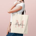 Modern Rose Gold Monogram Initial and Name Tote Bag<br><div class="desc">Elegant and feminine,  this tote features a large rose gold monogram initial with a personalised name in flowing dark script. A versatile monogram design that makes a beautiful bridesmaid proposal gift,  birthday present,  or everyday accessory for any woman who appreciates refined style. Initial and name are fully customisable.</div>