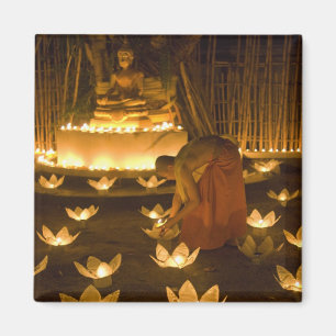Monks lighting khom loy candles and lanterns for magnet