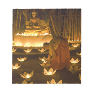 Monks lighting khom loy candles and lanterns for notepad