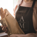 Monogram Black Personalised Apron<br><div class="desc">Cook in style with this Monogram Black Personalised Apron. Featuring a sleek black design and a customisable monogram, this apron adds a touch of sophistication to any kitchen. Made from durable and high-quality materials, it provides both comfort and protection, making it perfect for both amateur and professional chefs. Whether you're...</div>