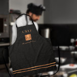 Monogram elegant black gold name script chef apron<br><div class="desc">Monogrammed stylish luxury exclusive kitchen restaurant master chef apron featuring a faux gold copper metallic glitter square and lines over a stylish classy faux black leather (PRINTED TEXTURE) background.           Personalise it with title,  name and initials.</div>