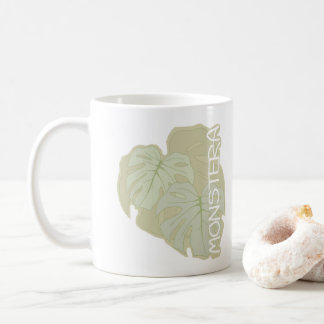 Monstera foliage in soft green coffee mug