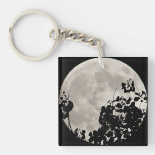 Moon behind dark leaves key ring