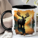 Moose in Autumn Lake Reflection  Mug<br><div class="desc">Experience the serene beauty of nature with the Moose in Autumn Lake Reflection Mug. This stunning mug features a majestic moose standing in a tranquil lake surrounded by vibrant autumn foliage, with the beautiful colours and scenery reflected in the water. Customised with your name, it adds a personal and unique...</div>