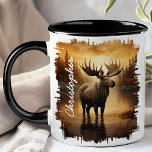 Moose in Misty Lake Reflection Mug<br><div class="desc">Savour your favourite beverage with the Moose in Misty Lake Reflection Mug. This captivating mug features a majestic moose standing in a misty lake, with the soft, golden hues of dawn and the tranquil forest beautifully reflected in the water. Customised with your name, it adds a personal and unique touch....</div>