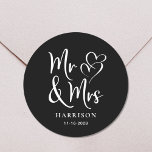 Mr Mrs Black Wedding Classic Round Sticker<br><div class="desc">A chic black sticker for your wedding correspondence and party favours featuring "Mr & Mrs" in a large white script and a white illustration of two hearts joined together. Add your name and wedding date.</div>