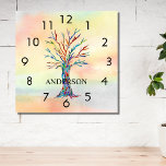 Name Monogram Rainbow Tree Square Wall Clock<br><div class="desc">This colourful Wall Clock is decorated with a mosaic tree in the colours of the rainbow on a watercolor background.
Easily customisable with your name or monogram.
Because we create our own artwork you won't find this exact image from other designers.
Original Mosaic and Watercolor © Michele Davies.</div>