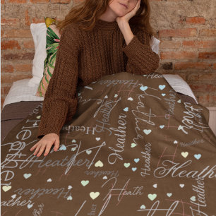 names initials and hearts replicated along brown fleece blanket