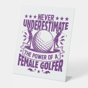 Never underestimate the power of a female golfer t pedestal sign