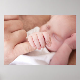 newborn baby holding fathers finger poster