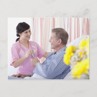 Nurse giving patient medication in hospital postcard