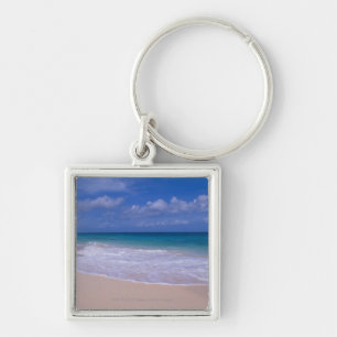 Ocean waves foaming onto sandy beach key ring