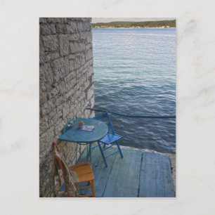 Oceanside seating for two at tiny outdoor cafe, postcard