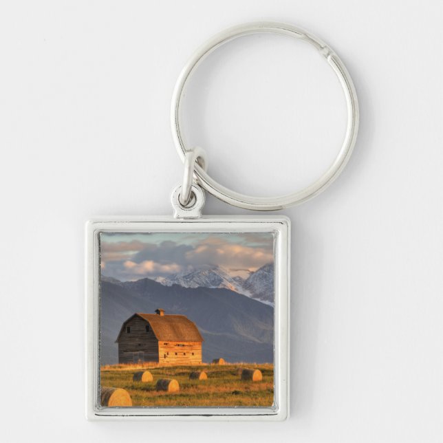 Old barn framed by hay bales and dramatic key ring (Front)