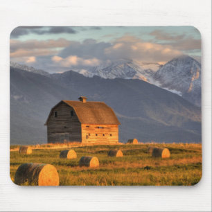 Old barn framed by hay bales and dramatic mouse pad