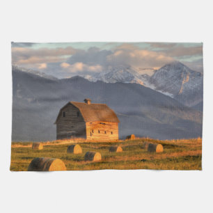 Old barn framed by hay bales and dramatic tea towel