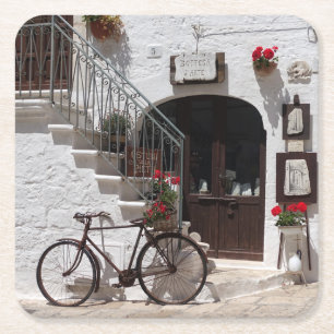 Old bike and storefront in Apulia Square Paper Coaster