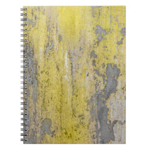Old grey concrete wall with peeling yellow paint. notebook