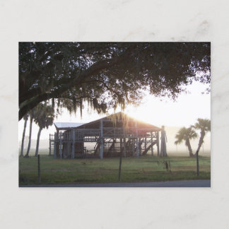 Old ranch building under trees with man statue postcard