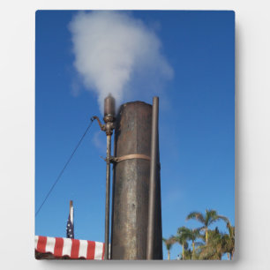 old steam whistle with a white plume of steam plaque