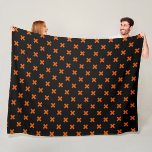 Orange cross stitches on black fleece blanket
