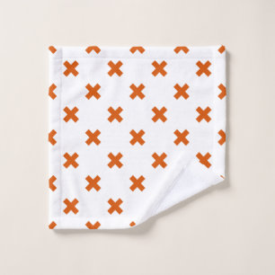 Orange cross stitches on white wash cloth
