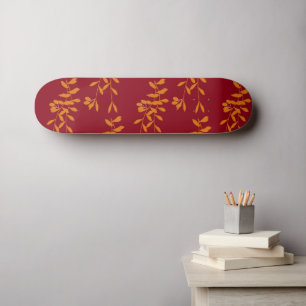 Orange silhouette branch leaves on red skateboard