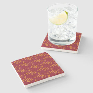 Orange silhouette branch leaves on red stone coaster