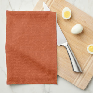 Orange textured surface with swirling pattern tea towel