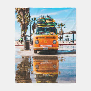 Orange van with surfboard on top fleece blanket