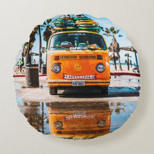 Orange van with surfboard on top round cushion