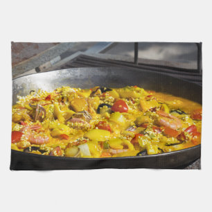 Paella is cooked on a grill tea towel