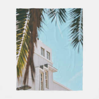 Palm tree near white concrete building fleece blanket