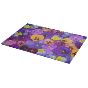 Pansy flowers floating in bird bath with dew cutting board