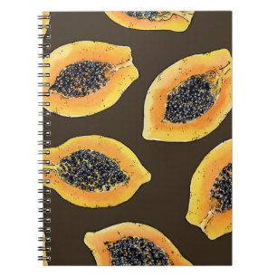 Papaya slices on dark brown notebook