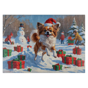 Papillon Dog Running in Snow with Christmas Hat Cutting Board