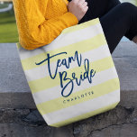Pastel Yellow and White Stripes Blue Team Bride Tote Bag<br><div class="desc">All-Over-Print Tote bag featuring the words "Team Bride" in blue trendy script against a pastel yellow and white stripes pattern background. Perfect for weddings for bridesmaids, maid of honour and flower girl. For other colours and matching items see here https://www.zazzle.com/collections/119250194970828530?rf=238364477188679314 Personalise it by replacing the placeholder text. For more options...</div>