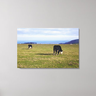 Pastoral scene of cows in field overlooking canvas print