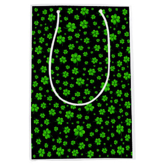 Pattern of green shamrocks on black background medium gift bag