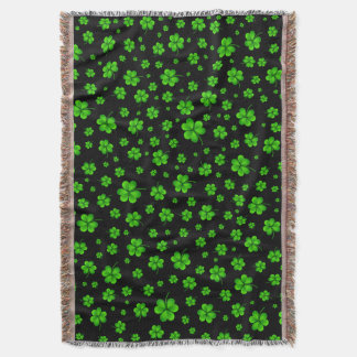 Pattern of green shamrocks on black background throw blanket