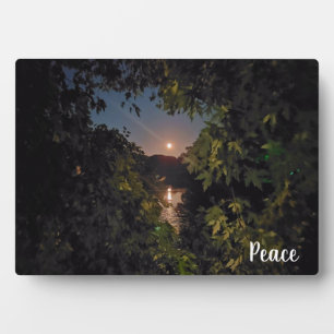 Peaceful moonrise in a blue sky over water plaque