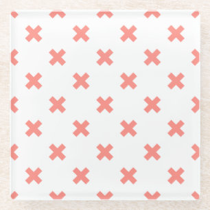 Peach cross stitches on white glass coaster