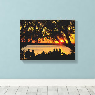 People by the river's edge at sunset canvas print