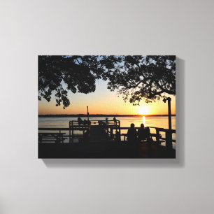 People fising on pier at sunset canvas print