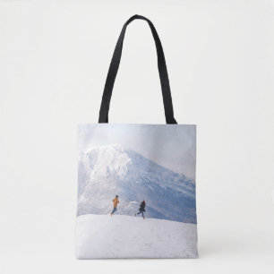 People having fun and running in mountains on the tote bag